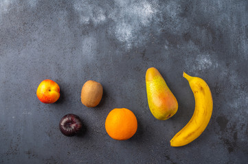 Ingredients for fruit salad on a dark wooden surface. Top view. Copy space