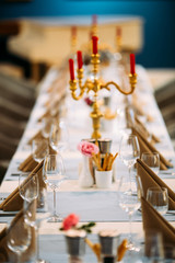 Served banquet table with candelabrum wine glasses
