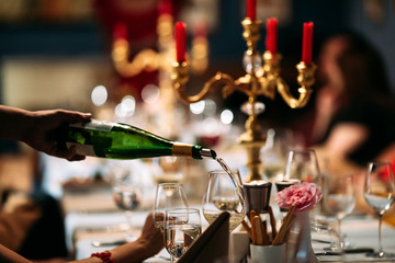 Waiter hand pouring wine in a glass served table