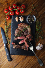 Grilled meat steak with blood cut on a stone Board with spices, top view