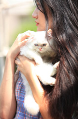 Beautiful young woman with cute white Persian cat resting at home