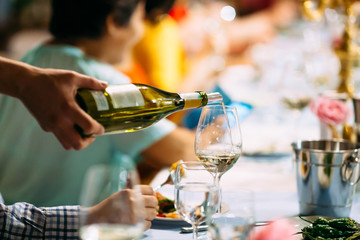 Waiter hand pouring wine in a glass served table