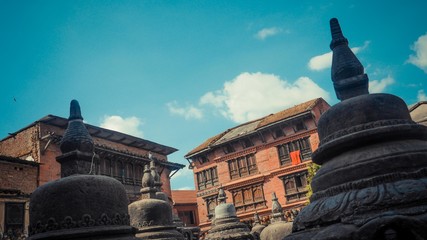 stone statues with a blue sky and a building
