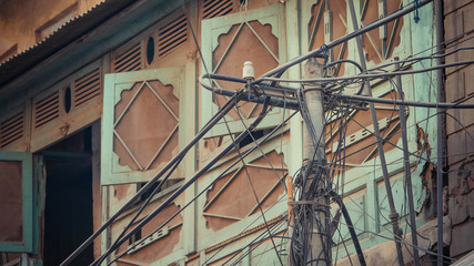 Fototapeta premium telephone wires hang on the pole with building in the back