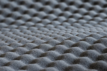 Abstract texture of embossed gray acoustic foam with selective focus