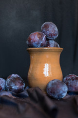 plums in a clay jug still life