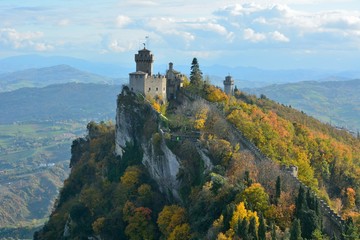 A part of the medieval San Marino city wall with the view of Italian landscape and Fratta or Cesta Tower at the back