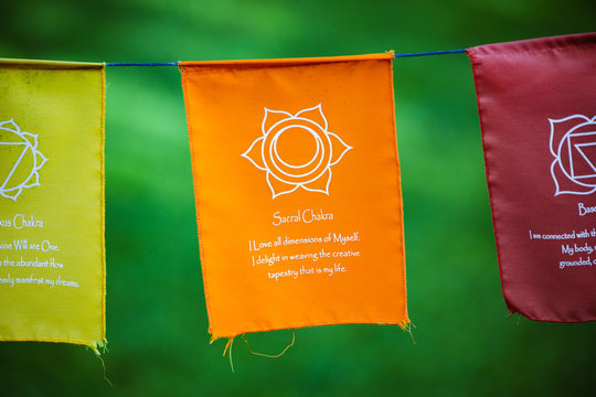 Chakra  Prayer flags hanging in the breeze. The orange flag is the sacral chakra