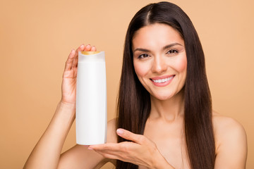 Closeup photo of attractive latin naked lady holding big white shampoo bottle advising buyers good...