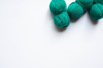top view of green wool yarn on white background with copy space