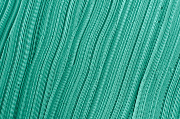 Fototapeta premium Green cosmetic clay (kelp facial mask, face cream, spirulina body wrap) texture close up, selective focus. Abstract background with brush strokes.