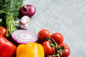 colorful fresh ripe vegetables with knife on grey concrete surface