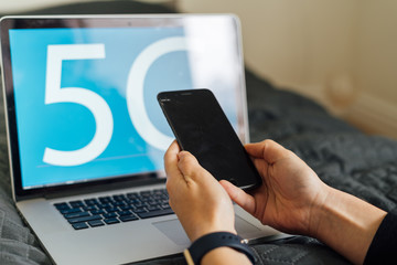 Blue background with 5G sign on laptop and person working. Fast mobile network. Evolution in technology