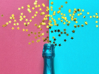 
Bottle of champagne with star confetti pouring out on duo colour background 
