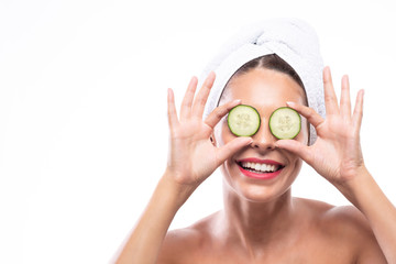 Attractive woman using cucumbers as a beauty remedy