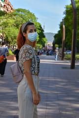 Woman walking in the park wearing surgical mask during coronavirus quarantine