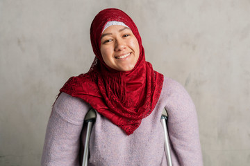 Happy Muslim woman with crutches