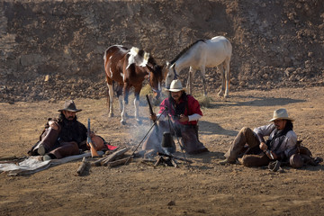 A group of cowboy men Sitting, drinking coffee to relax at their camping