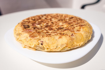 Close up view of an authentic homemade Spanish omelette made with eggs, potatoes and bacon. Traditional Spanish cuisine. Food and gastronomy concept. Homemade and traditional.