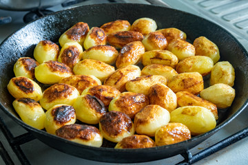Small fresh potatoes fried in olive oil on frying pan
