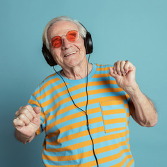 Happy senior man dancing while listening to music with headphones © rawpixel.com
