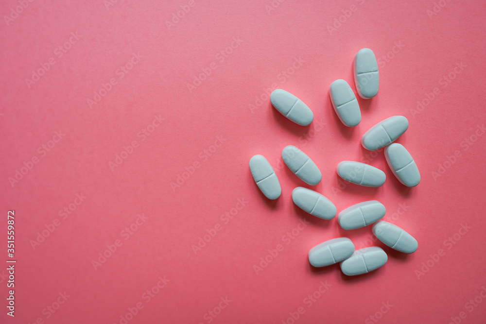 Wall mural White pills  on a colorful background with a free area for text