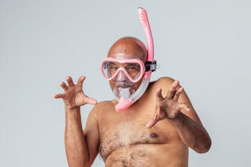 Funny senior African American man wearing a pink snorkel and goggles - obrazy, fototapety, plakaty