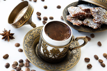 Turkish coffee with traditional turkish dessert cezerye and copper serving set. Feast of Ramadan. Cezerye is made with boiled carrots, sugar, pistachio and coconut. It is located dessert of Adana and 