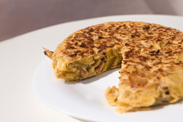 Interior view of an authentic homemade Spanish omelette made with eggs, potatoes and bacon. Traditional Spanish cuisine. Food and gastronomy concept. Homemade. Traditional. Copy space.
