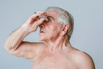 Senior man applying eye drops