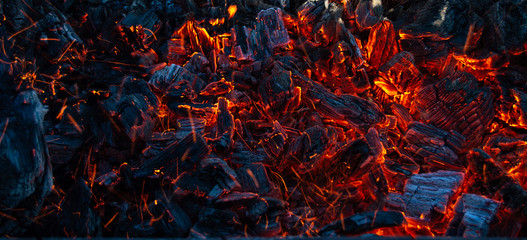 Burning coals in the dark, smoldering coal. Bright red sparks of fire. Background. - obrazy, fototapety, plakaty