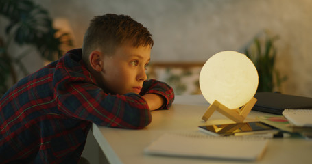 Boy changing color of table lamp