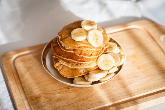 High Angle View Of Pancakes With Banana In Plate On Table