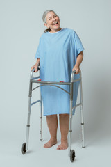 Happy patient in a hospital gown with a zimmer frame