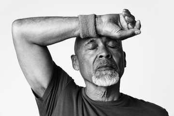 Athletic senior mean wiping off sweat from his forehead