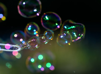 soap bubbles fly on a blurry green background. Concept - the Phantom of Hopes