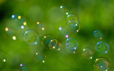 soap bubbles fly on a blurry green background. Concept - the Phantom of Hopes