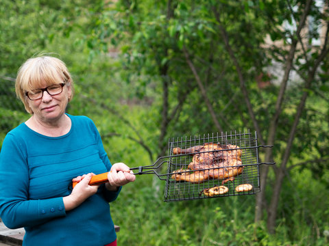 Senior Caucasian Woman Holding Barbecue Grilled Chicken