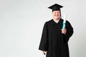 Cute boy with down syndrome in a graduation gown
