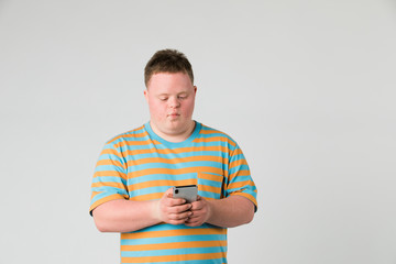 Cute boy with down syndrome using a mobile phone