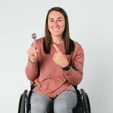 Cool Woman On A Wheelchair With A Vote Sticker On Her Index Finger