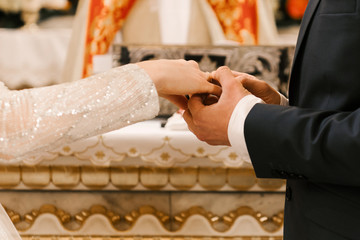 Hands of the bride and groom, wedding in the Church