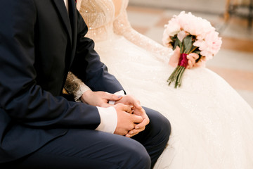 Obraz na płótnie Canvas Hands of the bride and groom, wedding in the Church