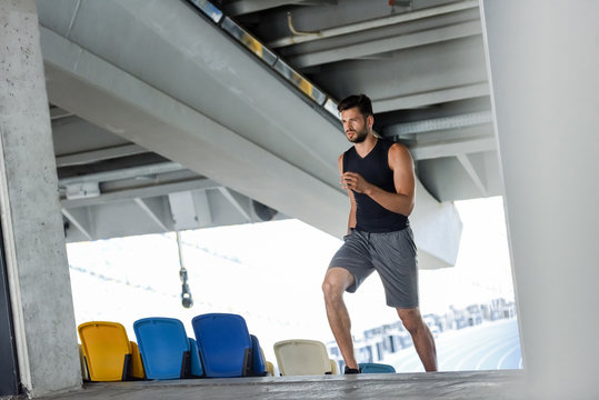 young sportsman running on stairs at stadium