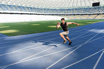 Fototapeta na wymiar handsome runner exercising on running track at stadium