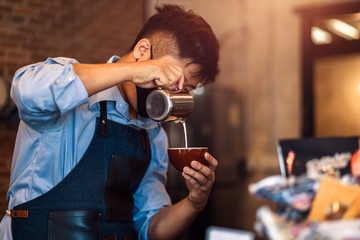 barista making cappuccino. Pouring milk for prepare cup of coffee. Latte art.