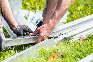 Two engineers putting together aluminium rails for photovoltaic system