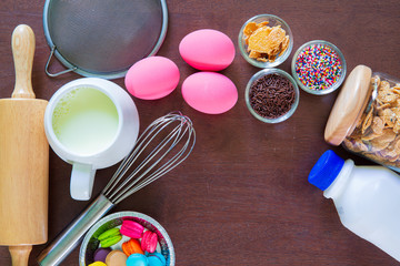 Baking cake in rural kitchen - dough recipe ingredients (eggs, flour, milk, butter, sugar) on vintage wooden table from above. Background layout with free text space