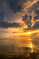 The ocean beach set with beautiful cloud and sun rays.