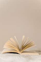 Book on top of bed open like a lotus flower and with smooth wall in the background